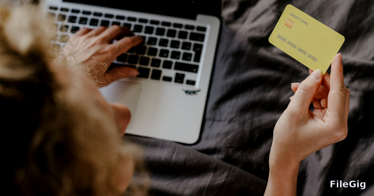 A person completing an online payment on a laptop, representing income earned each time a file is downloaded